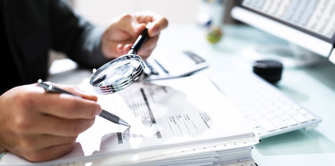 Tax Fraud: What to look for to stay vigilant. Photo of a man reviewing tax papers.