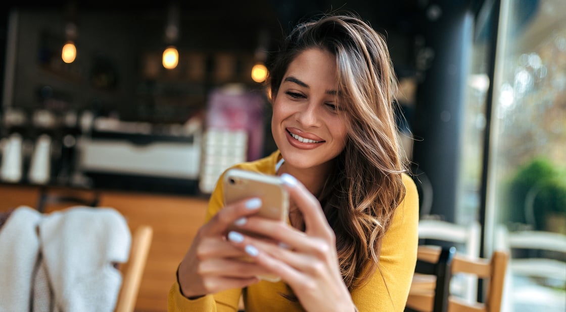 Woman using her mobile phone to utilize CCCU's new texting feature.