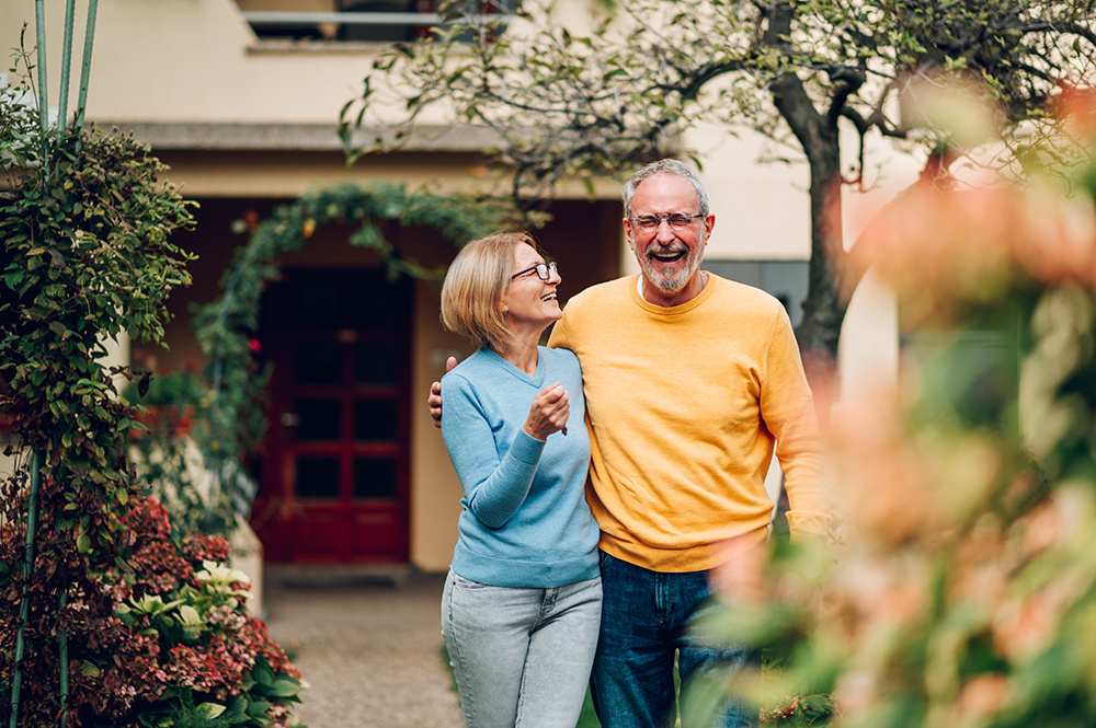 Couple outside of their home, who plans on refinancing their home with Consolidated Community Credit Union.